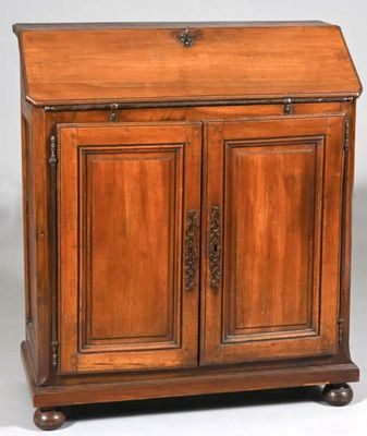 une vieille armoire en bois à deux portes, surmontée d'un tiroir
