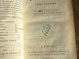 un vieux livre ouvert sur une table, avec un stylo à l'intérieur