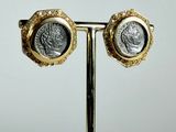 pair of gold and silver earrings with a roman coin on a stand