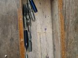a wooden box with a bunch of pens in it
