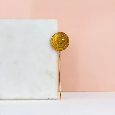 une pièce d'or posée sur un bloc de marbre