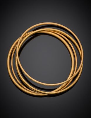 un ensemble de trois bracelets dorés sur fond noir