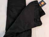 a pair of black pants laying on a white bed