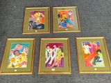 quatre tableaux encadrés représentant des femmes, de différentes couleurs et tailles, posés sur un tapis
