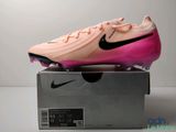 un gros plan sur une paire de chaussures roses et noires posées sur une boîte