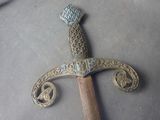 a metal sword with a wooden handle sitting on a table