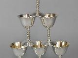 six silver goblets stacked on top of each other on a table