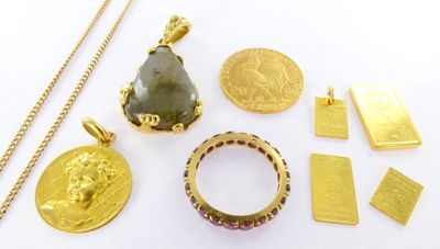 several gold and silver jewelry including a ring, pendant, and a coin
