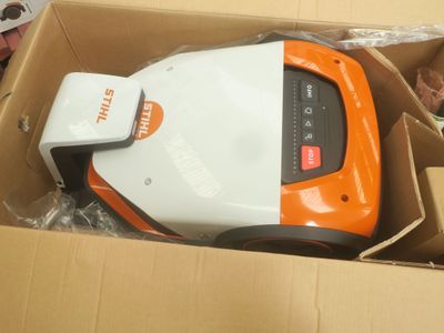 un aspirateur orange et blanc dans une boîte en carton