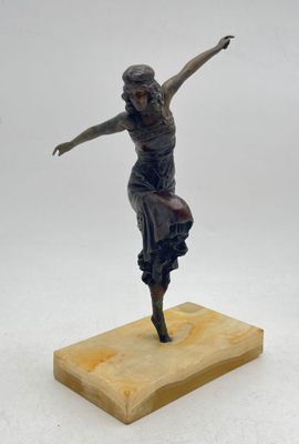 statue en bronze représentant une femme, posée sur un socle en bois, les bras tendus