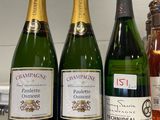 Trois bouteilles de champagne sont alignées sur un comptoir