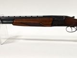 le fusil est posé sur un support transparent, sur une surface blanche