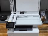 a white printer sitting on top of a wooden table next to boxes
