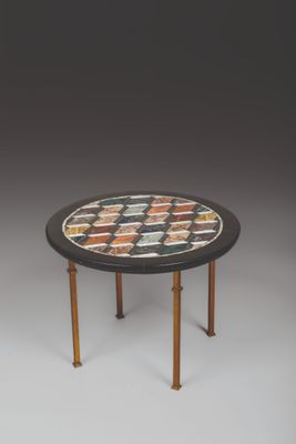 un gros plan d'une table avec un plateau en mosaïque et des pieds en bois