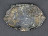 a metal object with a rose on it on a table