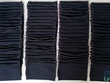 four pairs of black pants are lined up on a white surface