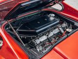 a red car with a black engine in the trunk