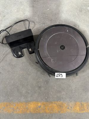 un gros plan d'un robot aspirateur posé au sol avec son chargeur