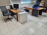 une photo d'une pièce avec un bureau équipé d'un ordinateur et un réfrigérateur