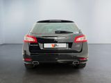 the rear end of a black car in a room with a white wall