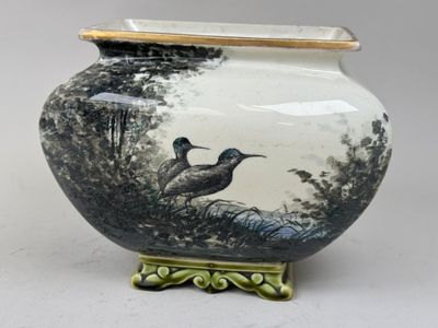 un vase avec un oiseau posé sur une table