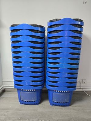 two blue plastic bins sitting on top of a wooden floor