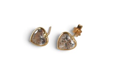 a pair of gold earrings with a heart shaped crystal