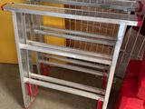 une étagère métallique posée à côté d'une chaise rouge