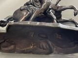a bronze statue of a man riding a horse with a dog