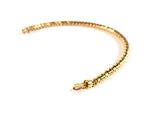 a close up of a gold bracelet on a white background