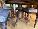 a table with four chairs and a bench in the middle of the room