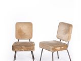 pair of mid - century style chairs with upholstered backrests and metal legs