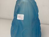 a blue vase with a label on it on a table