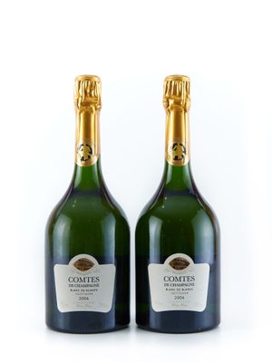 deux bouteilles de champagne posées l'une à côté de l'autre sur une surface blanche