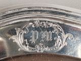 a close up of a silver plate with an ornate design on it