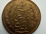 a close up of a gold coin with arabic writing on it