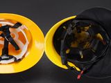 a yellow hard hat and a yellow helmet on a black table