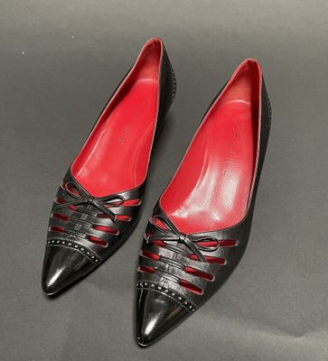 a pair of black and red shoes on a gray surface