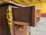 a close up of a wooden dresser with a gold handle