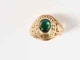 une image d'une bague en or avec une pierre verte au centre