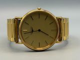 an image of a gold watch on a white surface