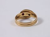 a close up of a gold ring with a red stone in it