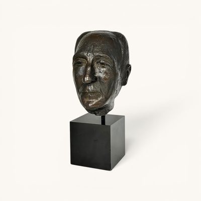 sculpture of a man ' s head on a black stand