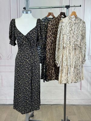 trois robes sur un mannequin sont posées devant un mur blanc