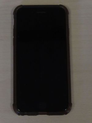 Un iPhone est posé sur une table, à côté d'une tasse de café.