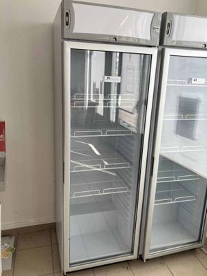 two refrigerators that are open in a room