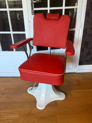 an image of a red and white barber chair in front of a door