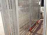 a large metal fence that is in the middle of a dirt field