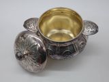 an antique silver plated bowl with a lid on a white surface