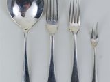 quatre fourchettes, une cuillère et une cuillère posées sur une table